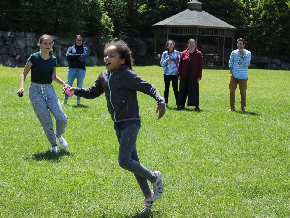 A young camper is cheered on by others